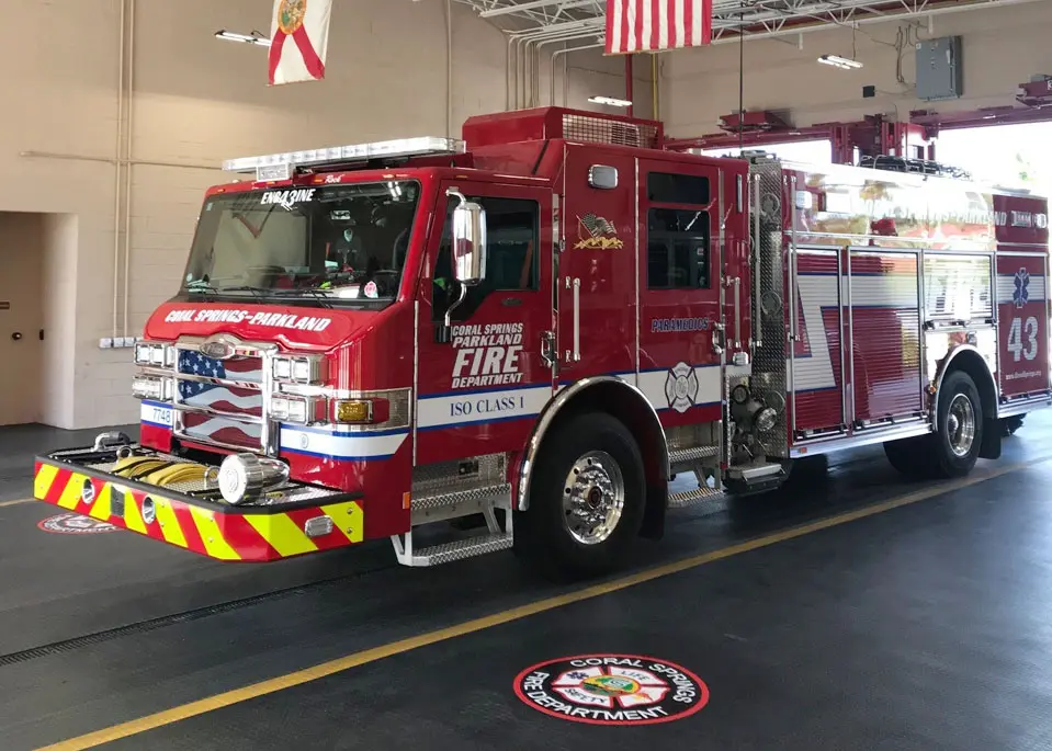 A fire truck parked in the garage of a building.