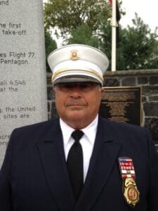 A man in uniform standing next to a stone wall.