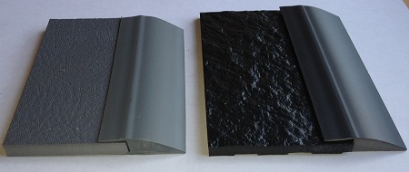 A black and grey piece of plastic next to a black object.